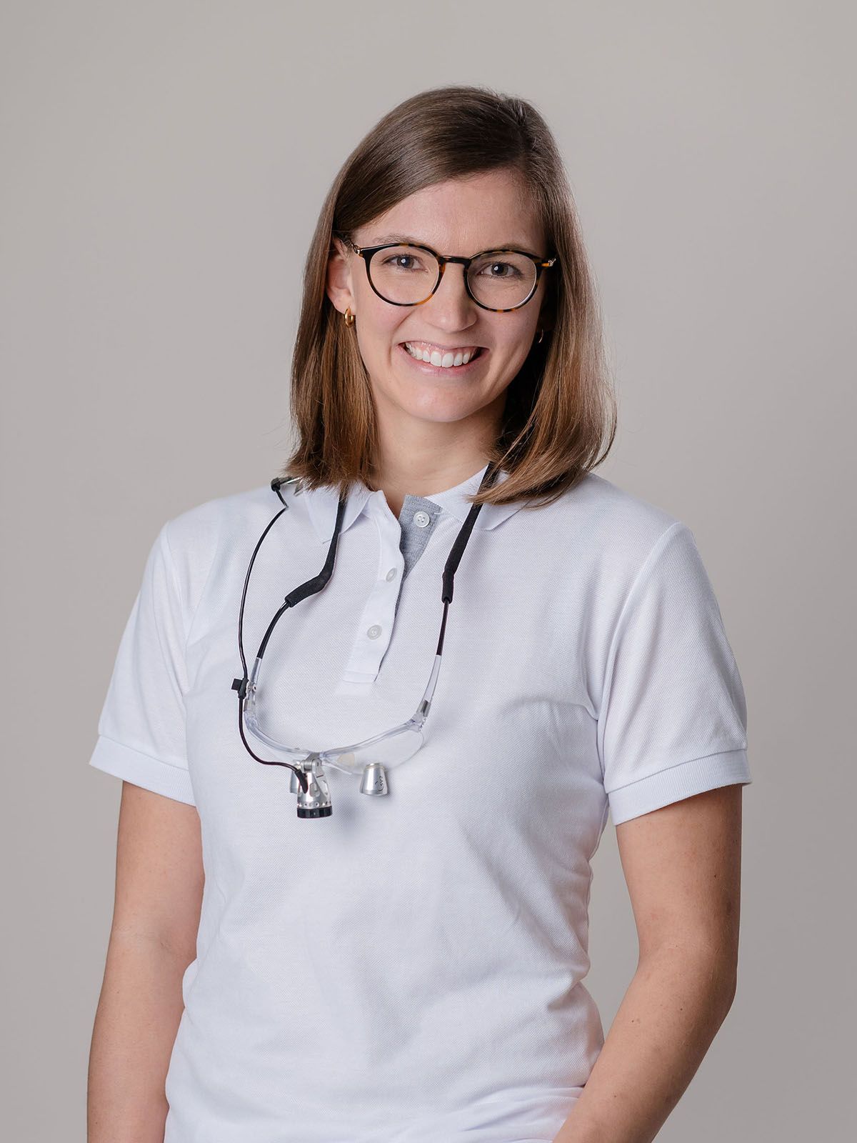Porträt von Dr. Verena Gernart, die vor schlichter weißer Wand steht