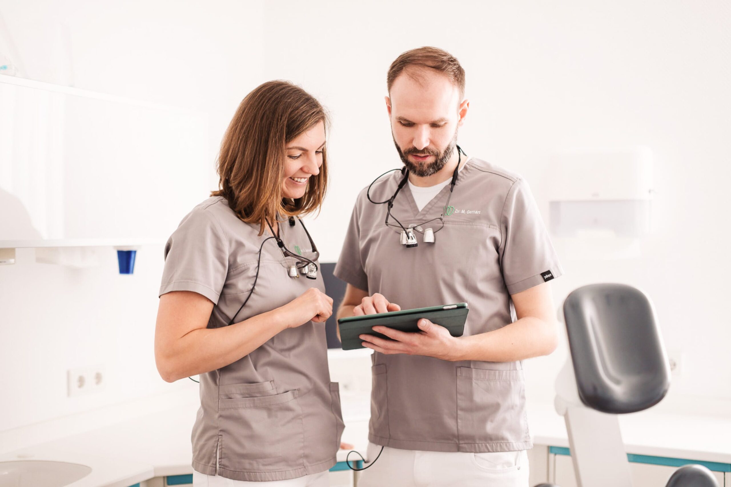 Zahnärzte Dr. Verena Gernart und Dr. Marvin Gernart besprechen einen Befund im Behandlunsszimmer